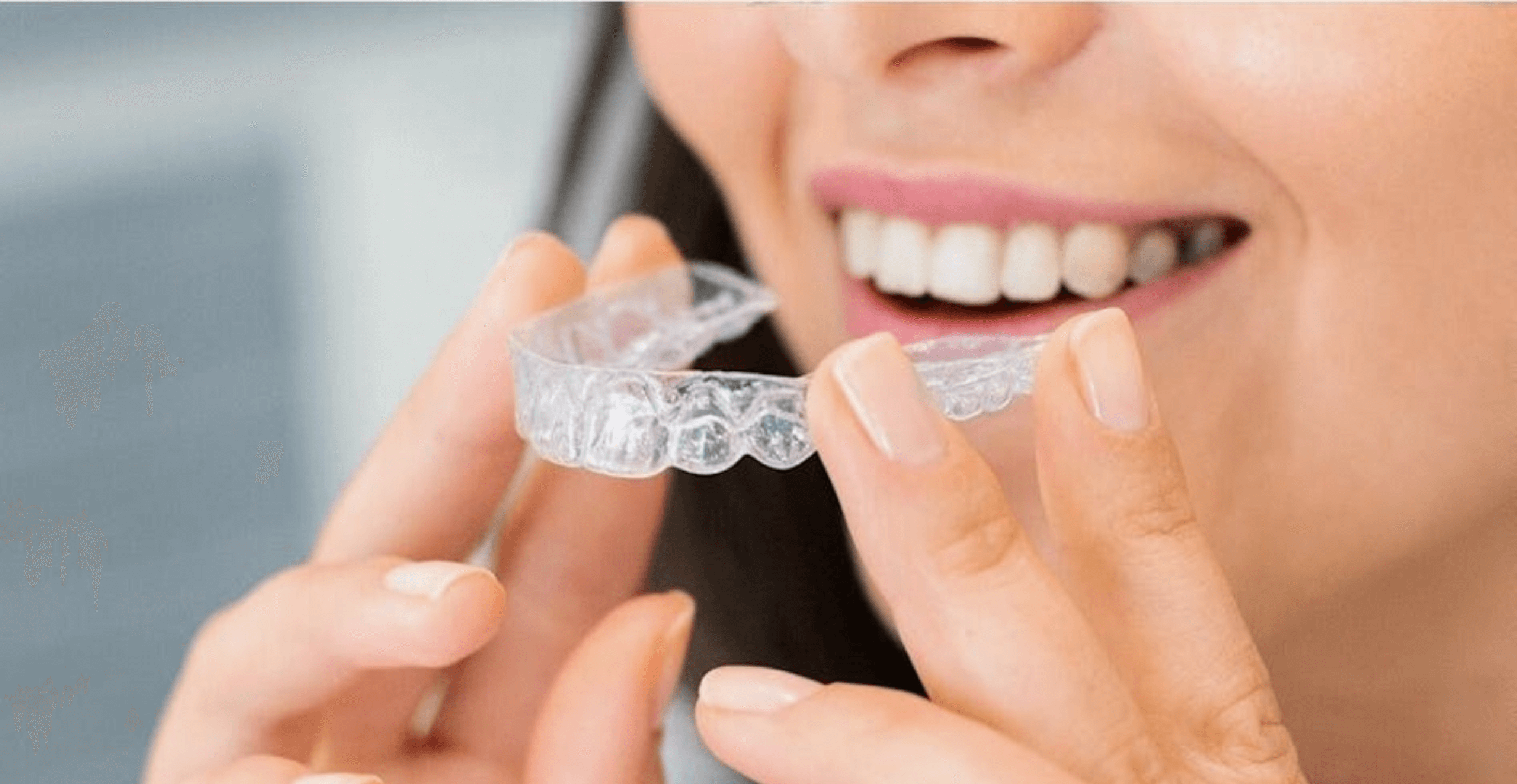 woman holding Invisalign aligners in front of her teeth at Beeston Dental Practice