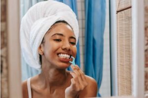 woman in mirror looking at teeth and gums