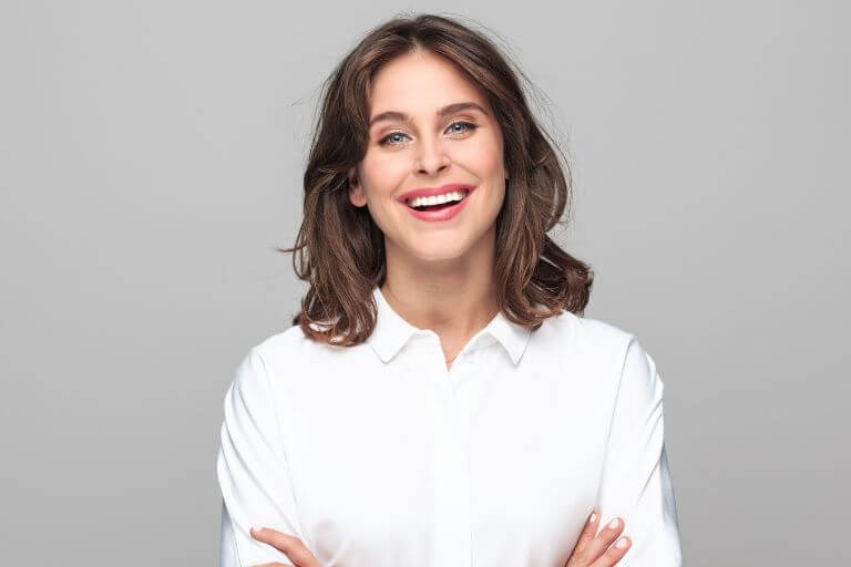 Woman smiling after tooth sensitivity treatment